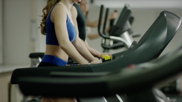 Pretty Smiling Blond Woman Walking On Treadmill