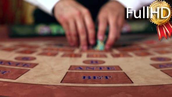 Croupier Moves Chips on Table at Casino
