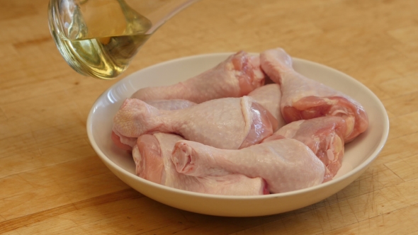 A Woman Prepares a Chicken With Potatoes In The Oven.  alt