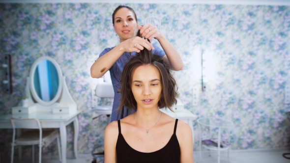 In The Professional Salon Haircuts, The Master Makes Hair Styling For a Young Girl. alt