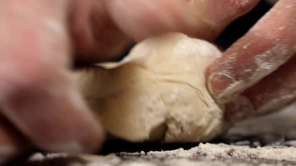 Closeup of Kneading Dough with Flour on the Table
