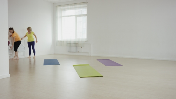 Yoga Class Doing Cobra Pose Together On Exercise Mats At The Gym alt