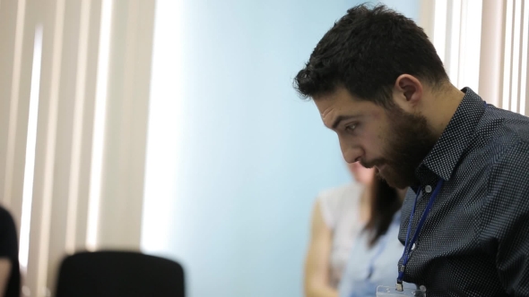 Man With Beard In Dark Shirt Is Prepared For Presentation At Conference.