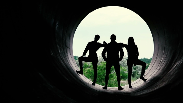 Silhouettes Of Young People On The Background Of a Large Hole.