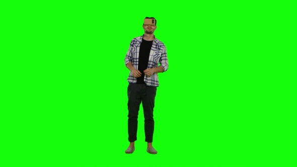 Young Man Trying Virtual Reality Glasses - VR Glasses - And Exploring Virtual Reality. Green Screen alt