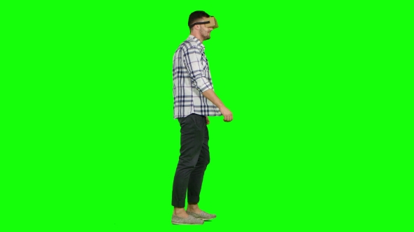 Man Plays Virtual Augmented Reality Game Using Head Mounted Display. Green Screen alt