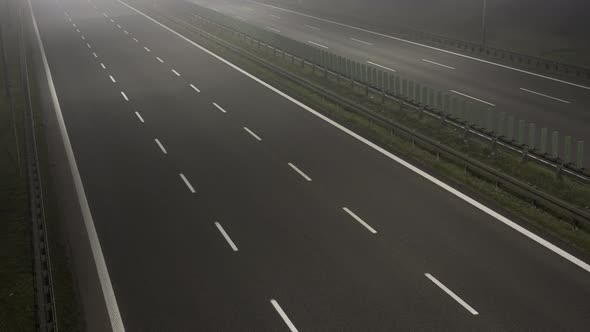 Cars Driving Fast on a Motorway or Highway with Fog or Mist