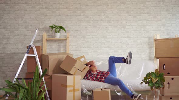 Man with Large Boxes in His Hands Falls on the Sofa alt