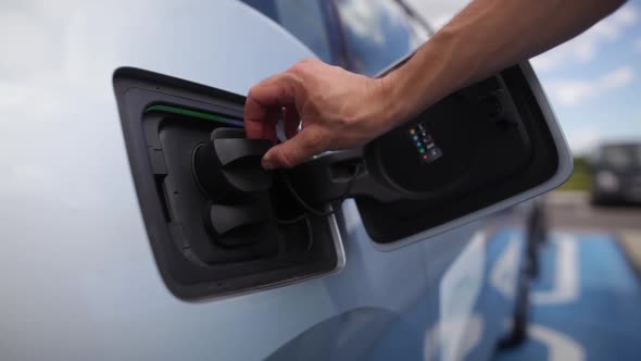 Hand closing the lid of an electrical car, after charging