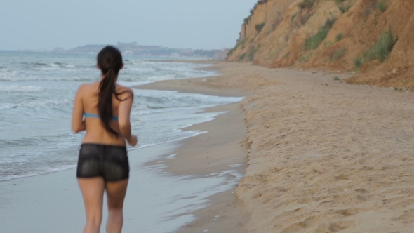 Morning Jogging Girl Along The Surf Line Of The Sea Beach In Summer