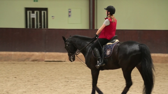 Girl Jockey Riding a Black Horse
