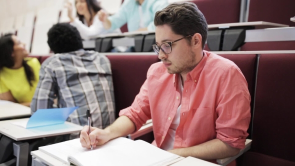 Students And Man Writing To Notebook On Lecture alt