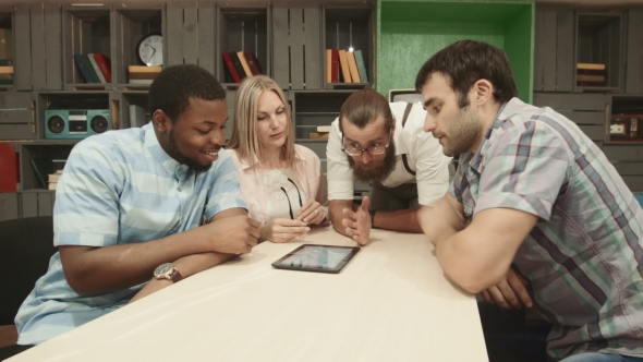 Mix-raced Group Of Businesspeople Using Tablet alt