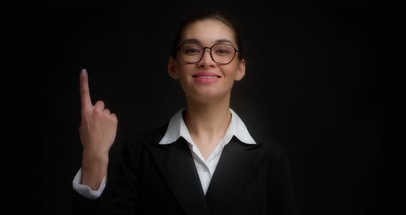Asian Woman in Glasses Smiling and Shows One Fingers with Her Right Hand