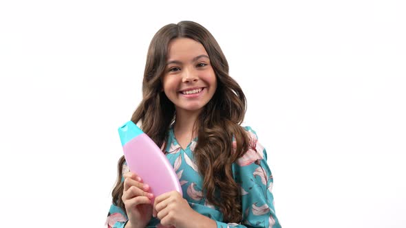 Cheerful Kid Girl with Curly Hair Offer to Wash Hair with Teen Shampoo Product Presenting Product alt