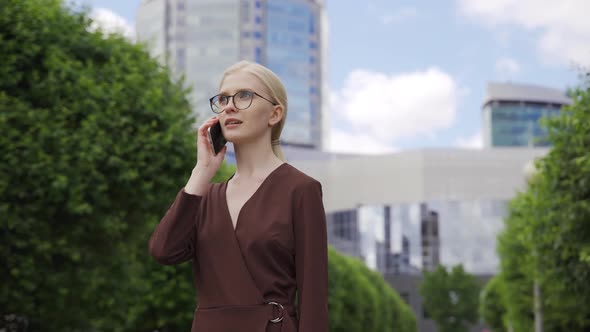 Business Woman with Glasses Answers the Call and Makes an Appointment