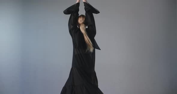 Blonde Attractive Female Dancer with Make Up in Long Black Dress Does Ballet Exercises and Tricks alt