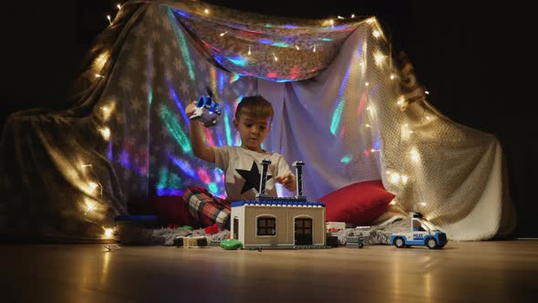 Little Boy Plays with Plastic Constructor at Home alt