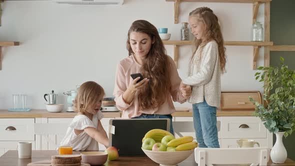 Busy Irritated Mother Tries To Work Remotely, Daughters Interfere with Mother's Work. alt