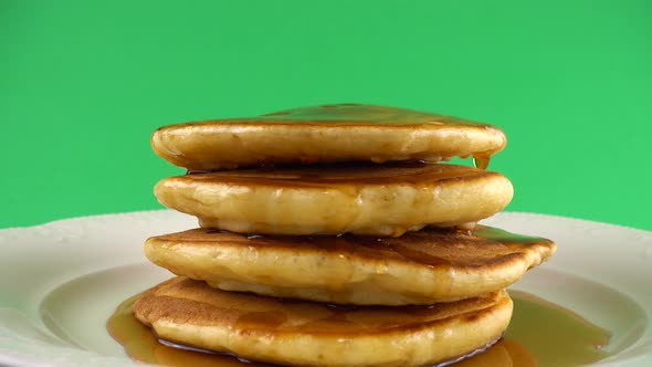 American pancakes with maple syrup on a green background. alt