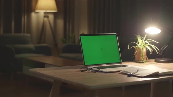 Laptop Computer Showing Green Chroma Key Screen Stands On A Desk In The Living Room alt