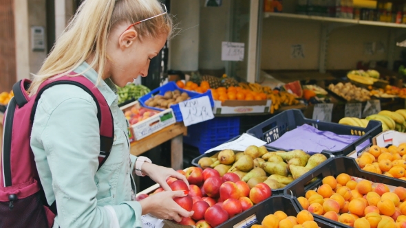 Woman Examining Fruits At The Street Market