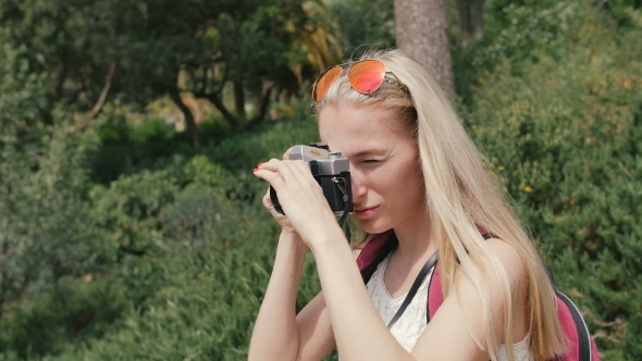 Young Woman With Retro Camera Take Photos In Park