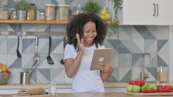 Young African Woman Doing Video Call on Tablet in Kitchen alt