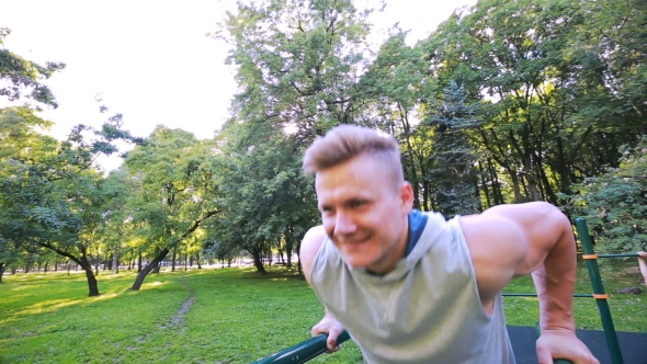 Young Man In Good Physical Shape, Is Engaged On The Bars