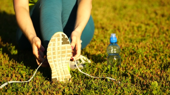 Girl Stopped Running To Tie The Laces On Running Shoes. Fitness Girl Training Outdoors.  alt