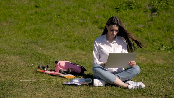 Young Pretty Hipster Student Girl Using Laptop In a Park, Net Surfing Outdoors alt
