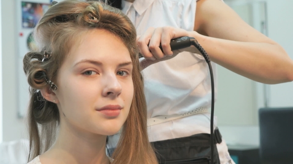 Master Makes The Curls To Girl At The Beauty Salon alt