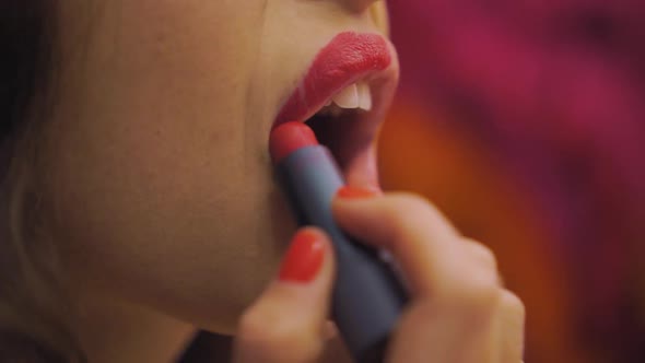 Beautiful Young Woman Paints Lips with Red Lipstick Makeup
