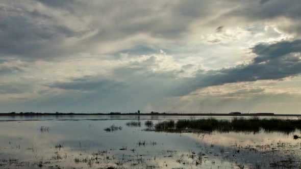 Sun Rays Through The Clouds Over The Lake
