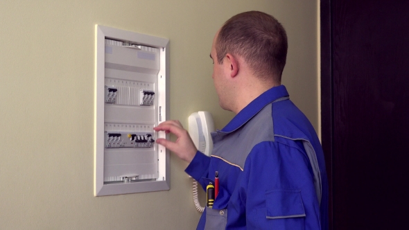 Specialist Man In Blue Uniform Turn On Circuit Breakers And Put Panel Door