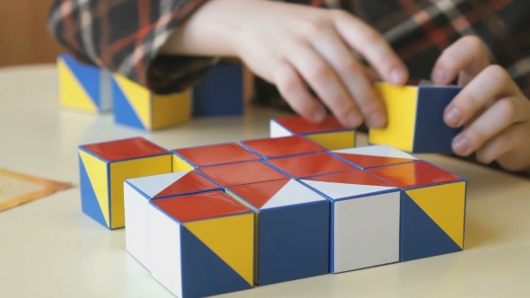 Child Collecting a Pattern Using Colored Cubes