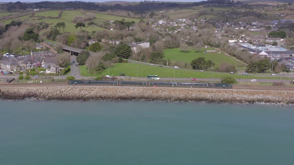 Commuter Train Travelling Slowly Alongside the Sea alt