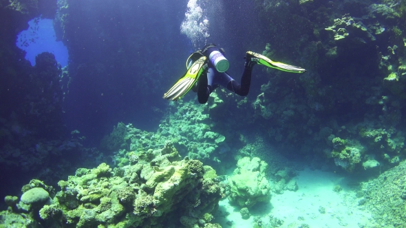 Diver Swim Through Underwater Cave