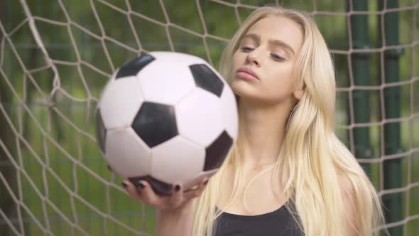 Close-up of Young Female Goalkeeper Posing with Ball on Outdoor Playground. Portrait of Confident alt