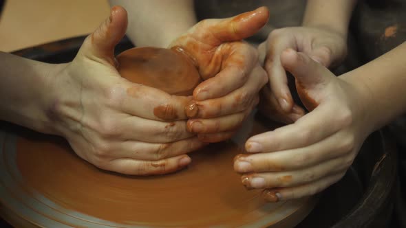 A Potter Shows How To Properly Hold a Piece of Clay on a Potter's Wheel
