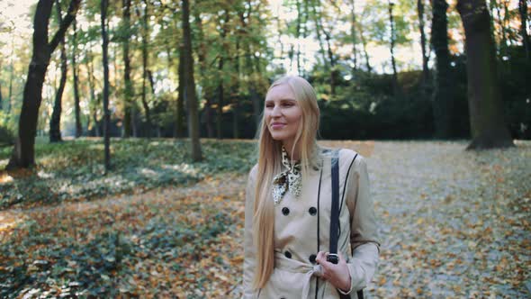 Beautiful Young Blonde Girl Walking in the Park in Autumn alt