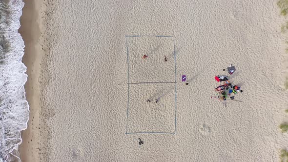 AERIAL: Young People Plays Volleyball on a Sand on a Lovely Evening alt