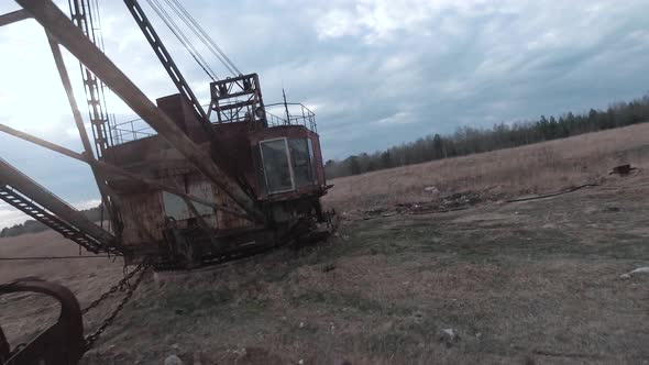 FPV Drone Flies Smoothly Near Rusty Abandoned Walking Excavator alt