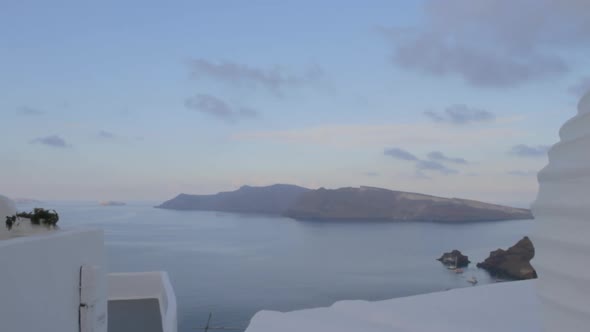 Tracking shot of the majestic caldera view in Oia, Santorini. Thirasia island seen in the background alt