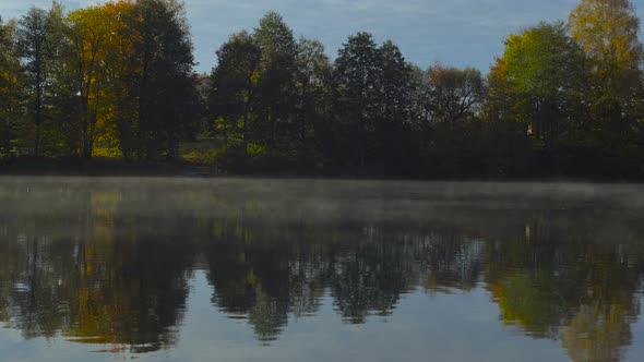 Natural Landscape Of Forest And Lake With Fog In Early Morning Over The Water