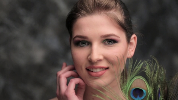 Girl With Colored Makeup And Peacock Feather