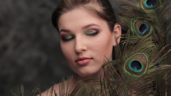 Model Blowing On The Peacock Feather