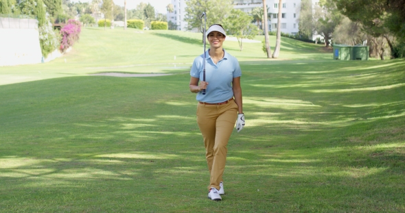 Smiling Friendly Woman Golfer Walking On a Course alt