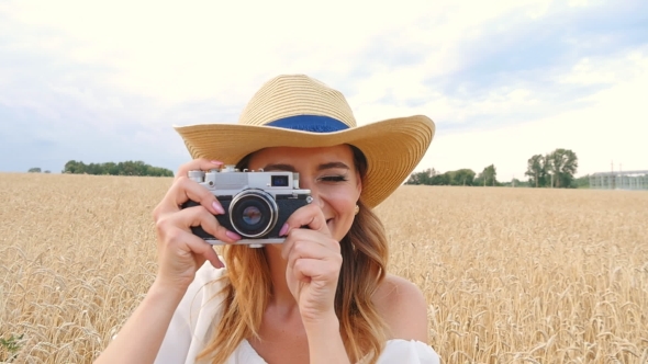 Woman Taking Photos With Retro Film Camera On The Field alt
