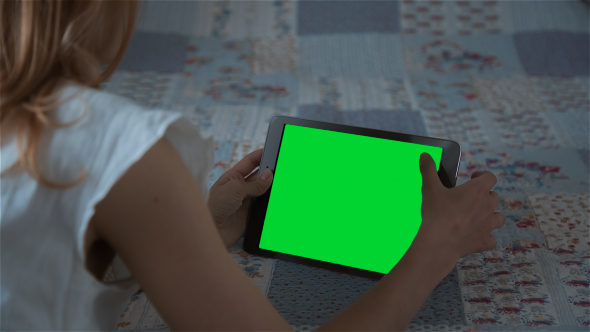 Beautiful Girl Using Tablet PC with Pre-Keyed Green Screen Lying on Bed at Home 6 alt